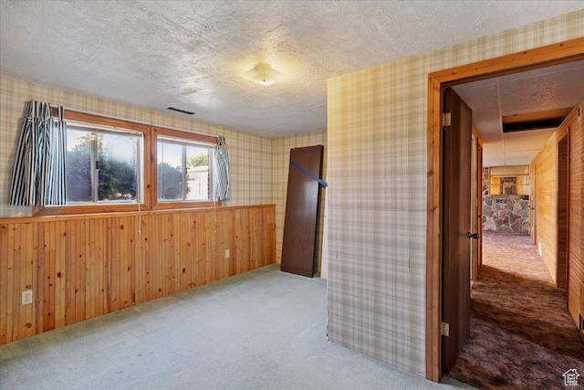 2989 W 700 S, Syracuse, UT 84075 - empty room featuring carpet floors, wood walls, a textured ceiling, and wallpapered walls