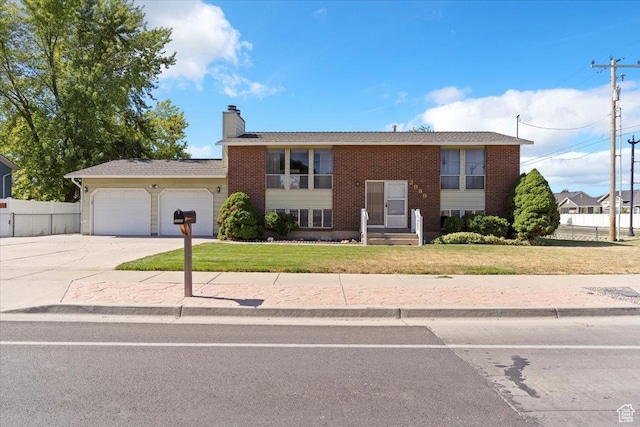 2989 W 700 S, Syracuse, UT 84075 - split foyer home featuring an attached garage, driveway, brick siding, and a chimney