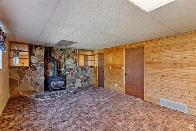 2989 W 700 S, Syracuse, UT 84075 - unfurnished living room with a wood stove, wooden walls, a paneled ceiling, and carpet