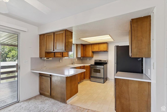 2989 W 700 S, Syracuse, UT 84075 - kitchen featuring stainless steel appliances, a peninsula, brown cabinetry, light countertops, and healthy amount of natural light