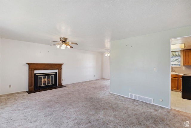 2989 W 700 S, Syracuse, UT 84075 - unfurnished living room with a ceiling fan, light carpet, and a fireplace with flush hearth