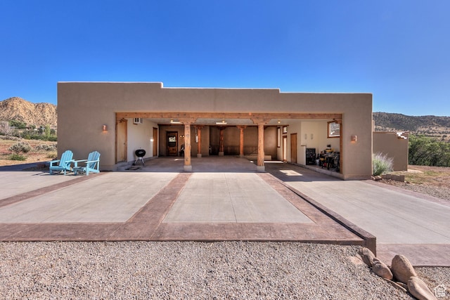 70 Desert Solitaire Rd, Moab, UT 84532 - view of front of home featuring a mountain view, driveway, a patio, and stucco siding