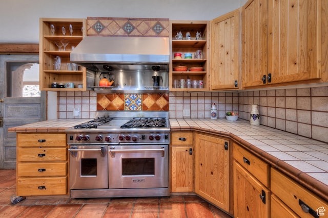 70 Desert Solitaire Rd, Moab, UT 84532 - kitchen with range with two ovens, open shelves, tile counters, extractor fan, and decorative backsplash