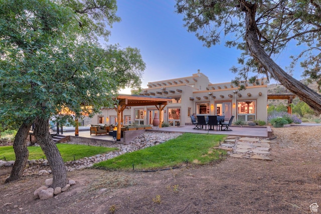 70 Desert Solitaire Rd, Moab, UT 84532 - back of house featuring an outdoor living space, a patio, stucco siding, and a yard