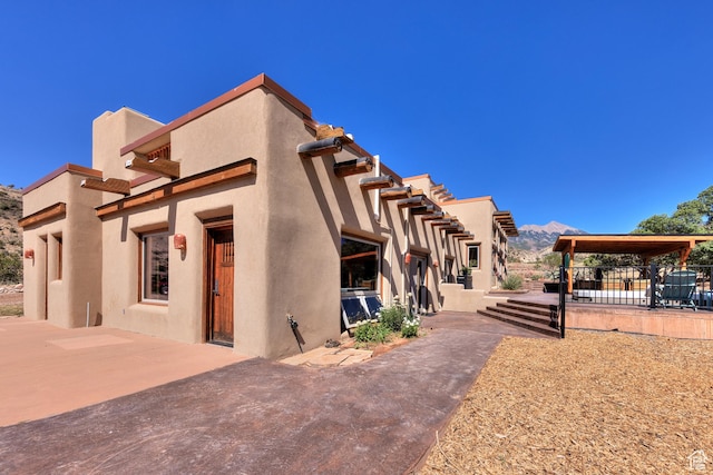 70 Desert Solitaire Rd, Moab, UT 84532 - view of side of home featuring a patio, stucco siding, and a mountain view