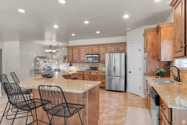 1066 W 575 N, Springville, UT 84663 - kitchen featuring appliances with stainless steel finishes, tasteful backsplash, brown cabinets, a kitchen breakfast bar, and a large island