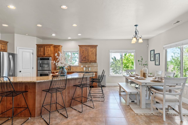 1066 W 575 N, Springville, UT 84663 - kitchen with brown cabinets, double oven, light stone countertops, recessed lighting, and a breakfast bar area