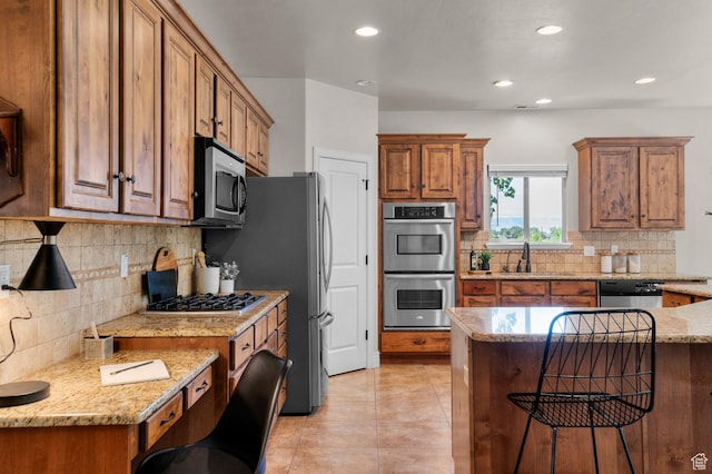1066 W 575 N, Springville, UT 84663 - kitchen featuring appliances with stainless steel finishes, backsplash, brown cabinetry, a breakfast bar, and recessed lighting