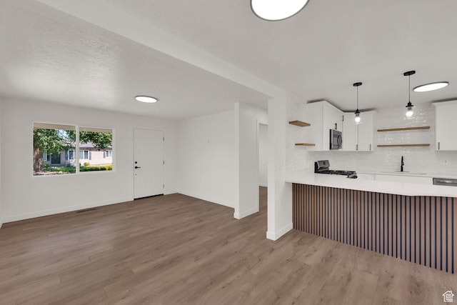 4243 W 5740 S, Salt Lake City, UT 84118 - kitchen featuring open shelves, stainless steel microwave, light countertops, gas range oven, and white cabinetry