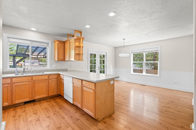 7861 N Tinamous Rd, Eagle Mountain, UT 84005 - kitchen with a textured ceiling, dishwasher, light wood-style floors, a peninsula, and light countertops