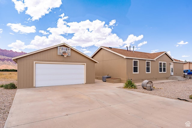 4568 Pueblo Verde Dr, Moab, UT 84532 - view of front of property with a detached garage, an outdoor structure, and a mountain view