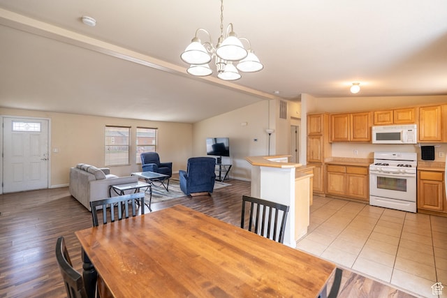 4568 Pueblo Verde Dr, Moab, UT 84532 - dining room featuring lofted ceiling, healthy amount of natural light, a chandelier, and light wood-style floors
