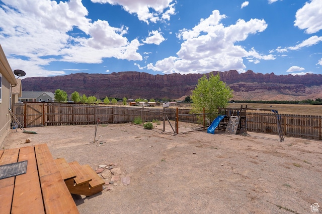 4568 Pueblo Verde Dr, Moab, UT 84532 - fenced backyard with a playground and a mountain view