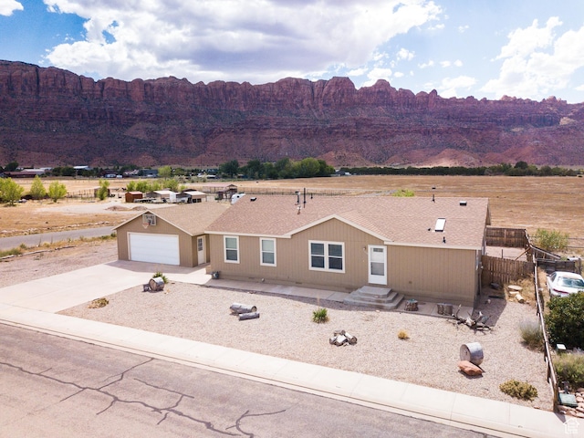 4568 Pueblo Verde Dr, Moab, UT 84532 - view of front of property with a mountain view, concrete driveway, and a shingled roof