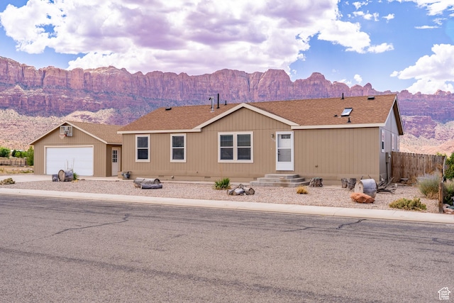 4568 Pueblo Verde Dr, Moab, UT 84532 - manufactured / mobile home with a mountain view, driveway, a shingled roof, and a garage
