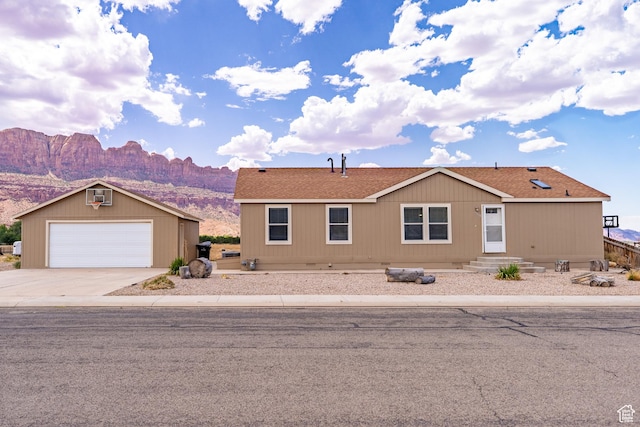 4568 Pueblo Verde Dr, Moab, UT 84532 - manufactured / mobile home with a mountain view, an outdoor structure, a shingled roof, and driveway