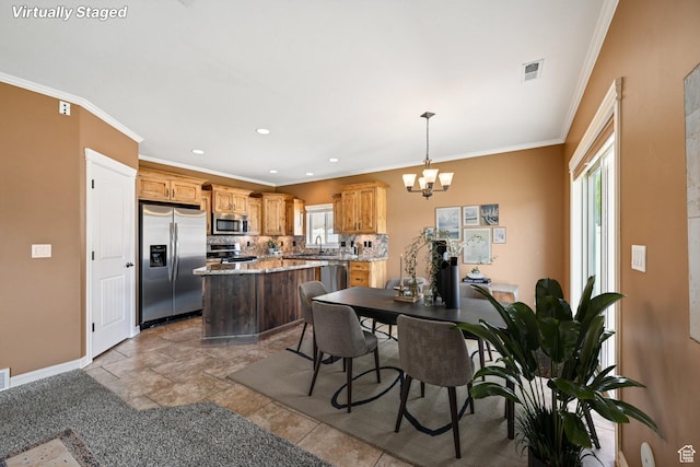 885 W 2150 N, Pleasant View, UT 84404 - kitchen featuring appliances with stainless steel finishes, healthy amount of natural light, a kitchen island, a chandelier, and ornamental molding