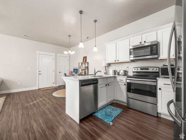 523 N 310 W, Vineyard, UT 84059 - kitchen with appliances with stainless steel finishes, a peninsula, a chandelier, dark wood-type flooring, and white cabinets