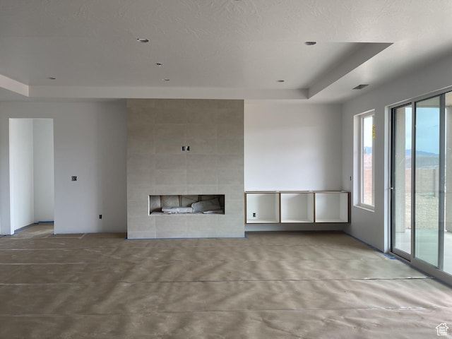 575 S 1800 W, Hurricane, UT 84737 - unfurnished living room with a tiled fireplace, a tray ceiling, and concrete floors