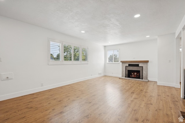 223 E 100 N, Bountiful, UT 84010 - unfurnished living room featuring recessed lighting, a premium fireplace, light wood finished floors, and a textured ceiling