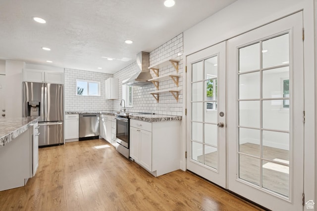 223 E 100 N, Bountiful, UT 84010 - kitchen featuring stainless steel appliances, ventilation hood, white cabinets, light wood-style floors, and backsplash