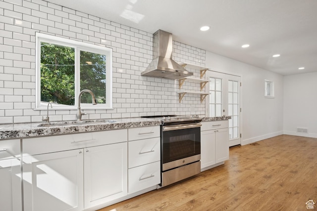 223 E 100 N, Bountiful, UT 84010 - kitchen with stainless steel electric stove, wall chimney exhaust hood, tasteful backsplash, light stone countertops, and white cabinetry