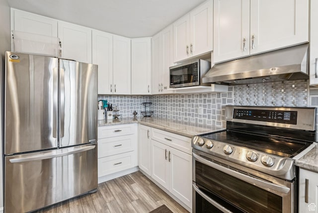 9355 S Peruvian Dr E, Sandy, UT 84093 - kitchen featuring appliances with stainless steel finishes, ventilation hood, white cabinetry, backsplash, and light stone counters