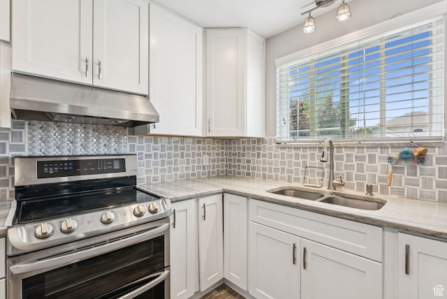9355 S Peruvian Dr E, Sandy, UT 84093 - kitchen featuring range with two ovens, under cabinet range hood, white cabinetry, and backsplash