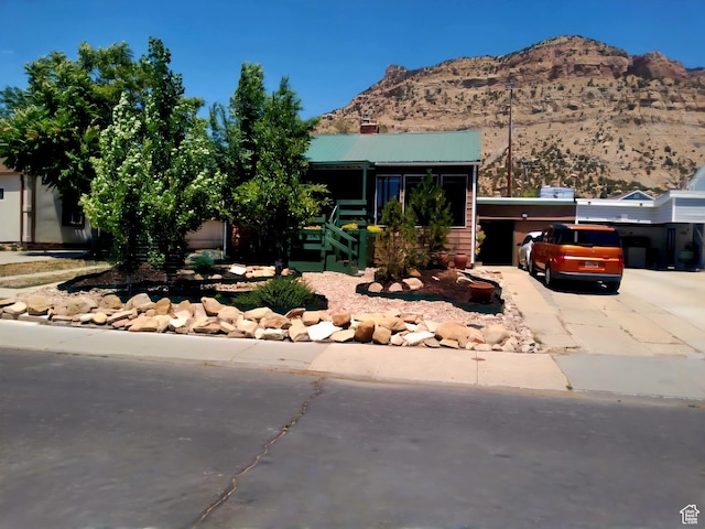 429 Edgehill Dr, Sunnyside, UT 84539 - view of front facade featuring concrete driveway, a mountain view, and a metal roof