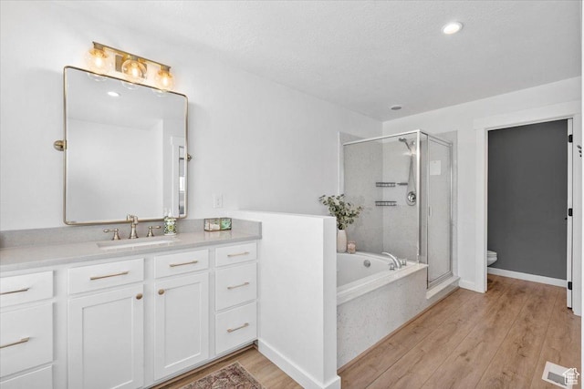 15181 S Sabre Pl, Bluffdale, UT 84065 - bathroom featuring vanity, a shower stall, a bath, wood finished floors, and a textured ceiling