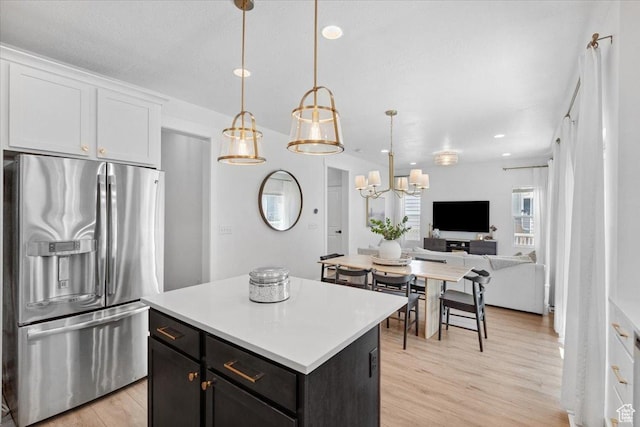 15181 S Sabre Pl, Bluffdale, UT 84065 - kitchen featuring stainless steel refrigerator with ice dispenser, a kitchen island, light countertops, open floor plan, and light wood-type flooring
