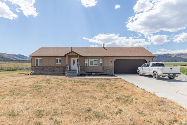 26551 N 8800 W, Portage, UT 84331 - single story home with stone siding, a mountain view, an attached garage, concrete driveway, and a front lawn