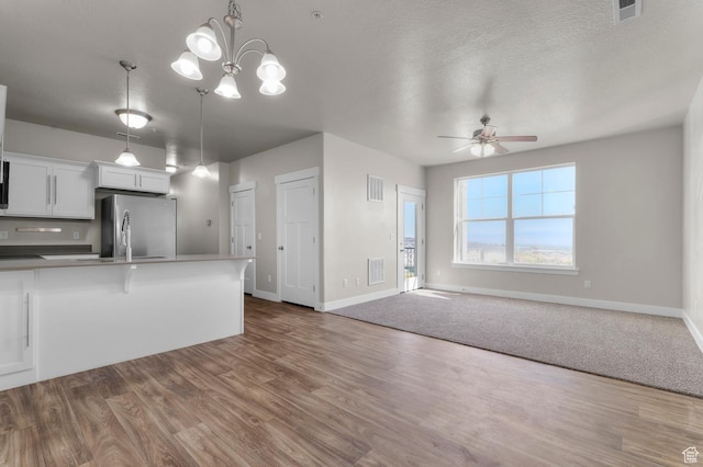 14643 S Mckellen Dr Unit D202, Herriman, UT 84096 - kitchen with freestanding refrigerator, ceiling fan, open floor plan, white cabinetry, and a textured ceiling