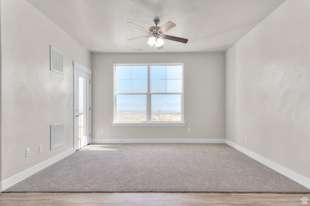 14643 S Mckellen Dr Unit D202, Herriman, UT 84096 - carpeted spare room featuring a ceiling fan, wood finished floors, and a textured ceiling