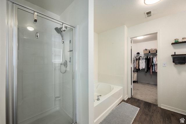 6733 W Mary Leizan Ln, Herriman, UT 84096 - bathroom featuring a shower stall, a bath, a spacious closet, and wood finished floors