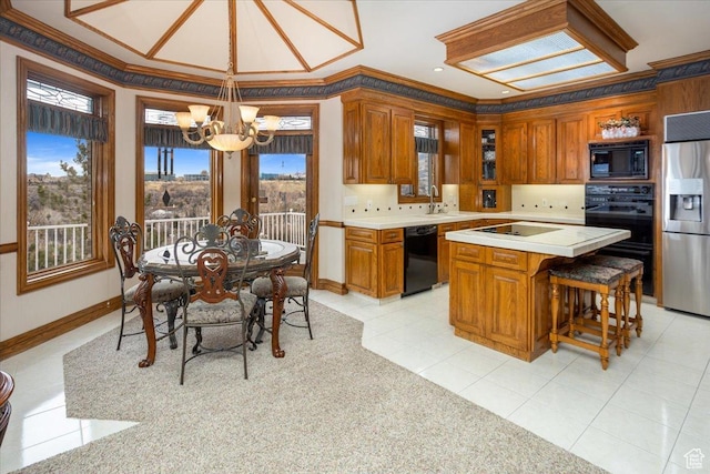 27 Canterbury Ln, Logan, UT 84321 - kitchen featuring black appliances, a chandelier, light countertops, brown cabinetry, and crown molding
