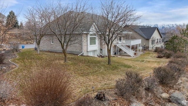 27 Canterbury Ln, Logan, UT 84321 - back of property with stairway, brick siding, a deck, and a yard