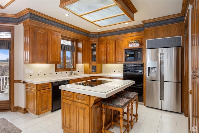 27 Canterbury Ln, Logan, UT 84321 - kitchen with black appliances, crown molding, brown cabinetry, decorative backsplash, and a center island