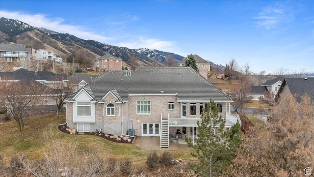 27 Canterbury Ln, Logan, UT 84321 - rear view of property featuring a patio area, a deck with mountain view, a tiled roof, french doors, and a residential view