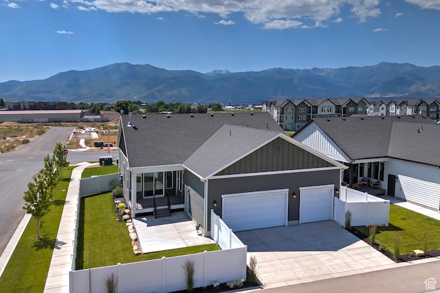 1919 S Sawmill Blvd E, Heber City, UT 84032 - view of front facade with an attached garage, board and batten siding, a mountain view, and a fenced backyard