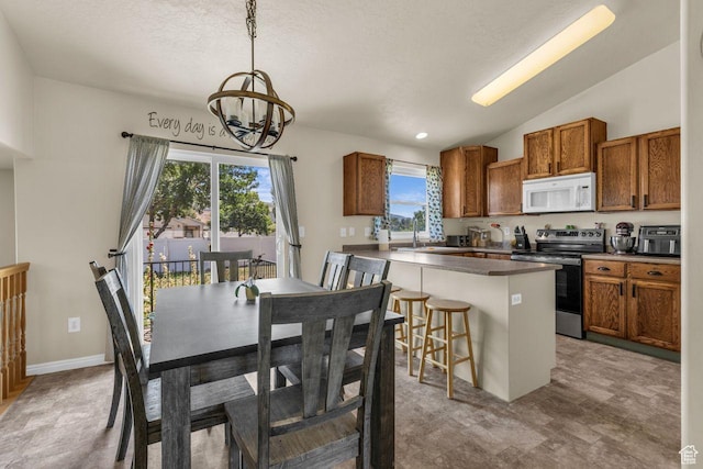 158 N Walton Ct W, North Salt Lake, UT 84054 - kitchen featuring white microwave, stainless steel range with electric stovetop, a chandelier, brown cabinetry, and healthy amount of natural light