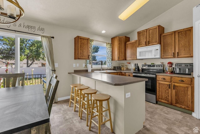 158 N Walton Ct W, North Salt Lake, UT 84054 - kitchen with white microwave, stainless steel range with electric stovetop, plenty of natural light, a kitchen bar, and lofted ceiling