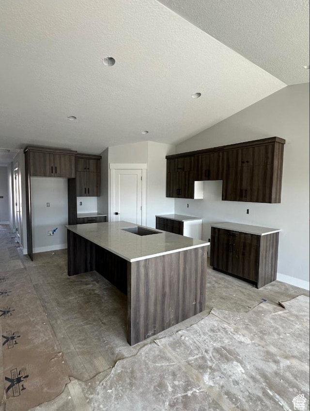 2655 S 2430 W Unit 116, Syracuse, UT 84075 - kitchen featuring a textured ceiling, a large island, vaulted ceiling, and modern cabinets
