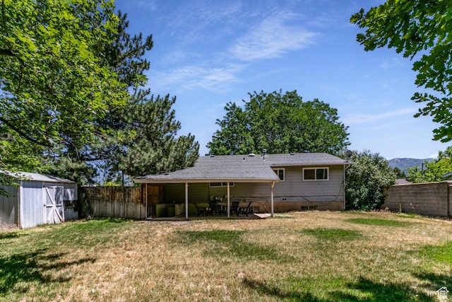 1844 Sorrento Dr, Woods Cross, UT 84087 - rear view of house with a fenced backyard, a storage shed, and a patio area