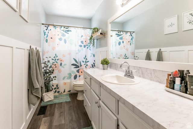 1844 Sorrento Dr, Woods Cross, UT 84087 - bathroom featuring vanity, wood finished floors, wainscoting, a decorative wall, and a shower with curtain