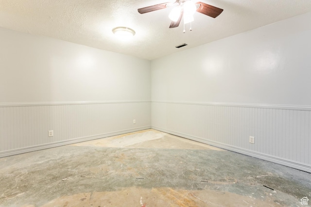 1844 Sorrento Dr, Woods Cross, UT 84087 - empty room with concrete floors, a wainscoted wall, ceiling fan, and a textured ceiling