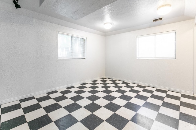 1844 Sorrento Dr, Woods Cross, UT 84087 - empty room with plenty of natural light, a textured ceiling, a textured wall, and tile patterned floors