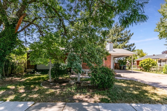 1844 Sorrento Dr, Woods Cross, UT 84087 - obstructed view of property with driveway, a chimney, a carport, and a front yard