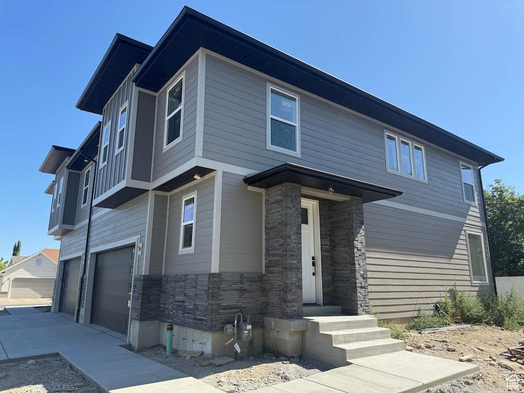 7433 S 410 E, Midvale, UT 84047 - view of front of property featuring an attached garage, driveway, stone siding, and brick siding