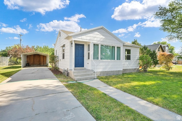 363 E Factory St, Garland, UT 84312 - view of front of home featuring a carport, concrete driveway, a front yard, and roof with shingles
